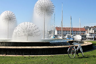 Bicycle parked near dandelion fountain in harbor