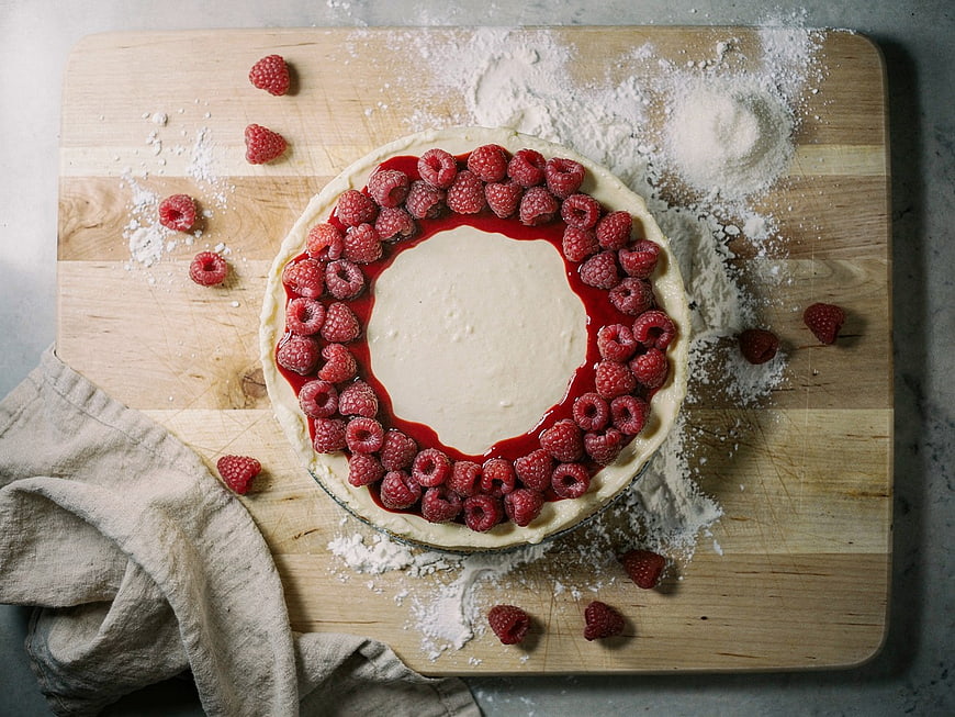 Raspberry Cheesecake on Wooden Board with Flour