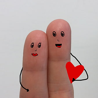 Finger puppets couple holding red heart on white background