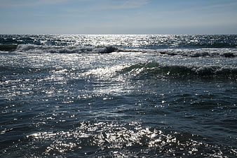 Sparkling ocean waves reflecting sunlight on a clear day