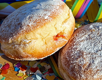 Close-up of powdered sugar donuts with colorful confetti and streamers