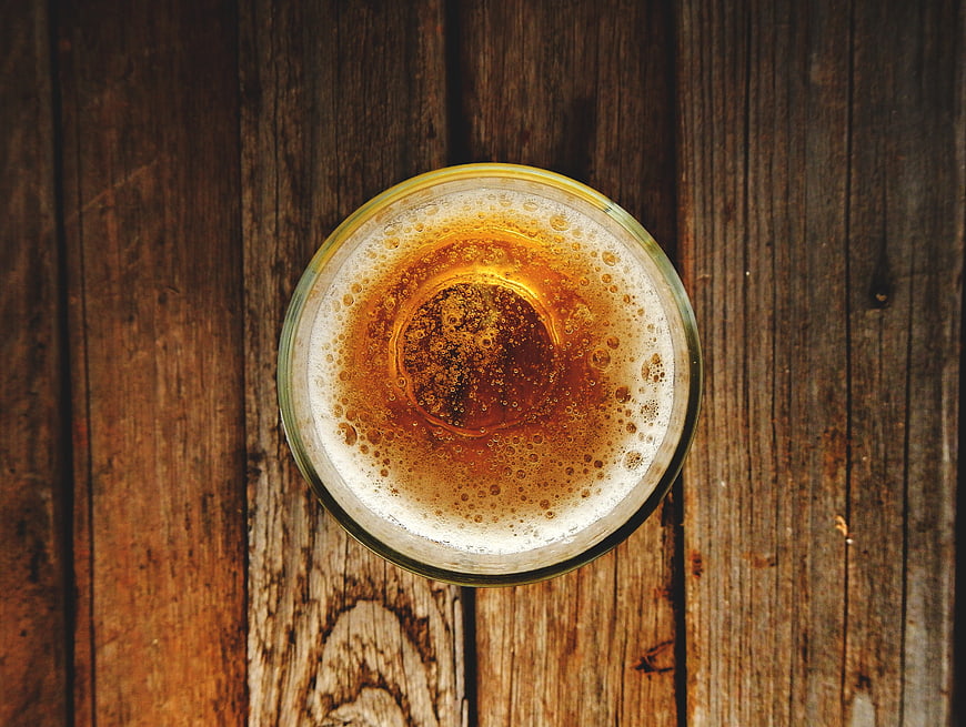 Top View of Amber Beer in Glass on Rustic Wood