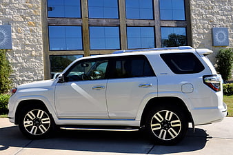 White Toyota 4Runner SUV Parked In Front Of Stone Building