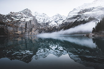 Misty Snow-Capped Mountains Reflected in Calm Alpine Lake
