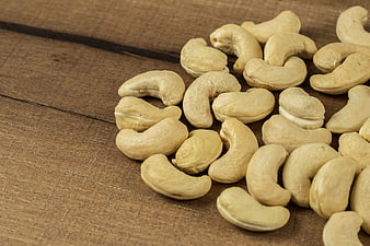 Raw Cashew Nuts Scattered On Rustic Wooden Surface