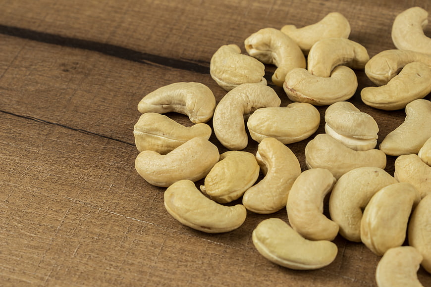 Raw Cashew Nuts Scattered On Rustic Wooden Surface
