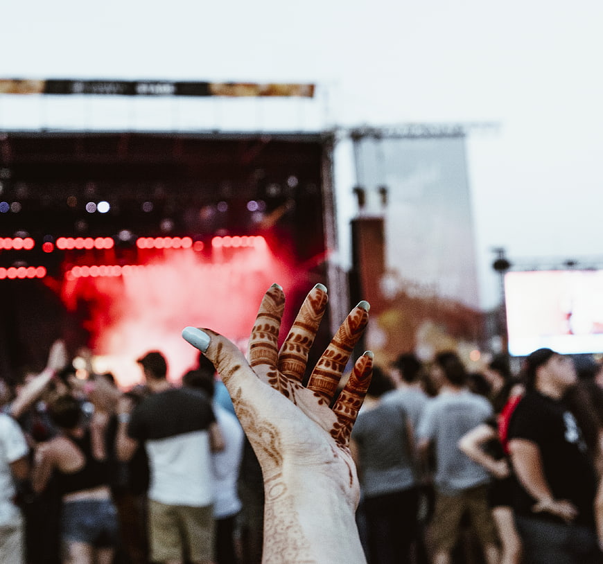 Hand with henna raised at outdoor music festival
