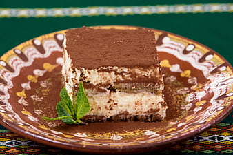 Classic Tiramisu Slice on Decorative Ceramic Plate with Mint Garnish