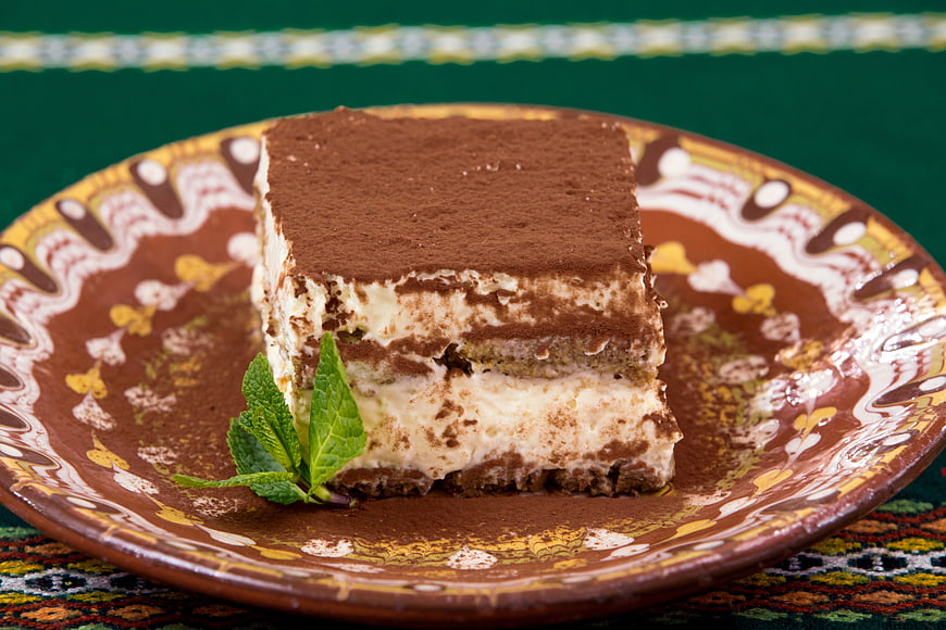 Classic Tiramisu Slice on Decorative Ceramic Plate with Mint Garnish