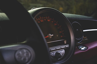 Close-up of vintage car dashboard with speedometer and steering wheel