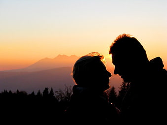 Silhouette of Couple Kissing at Sunset with Mountain View
