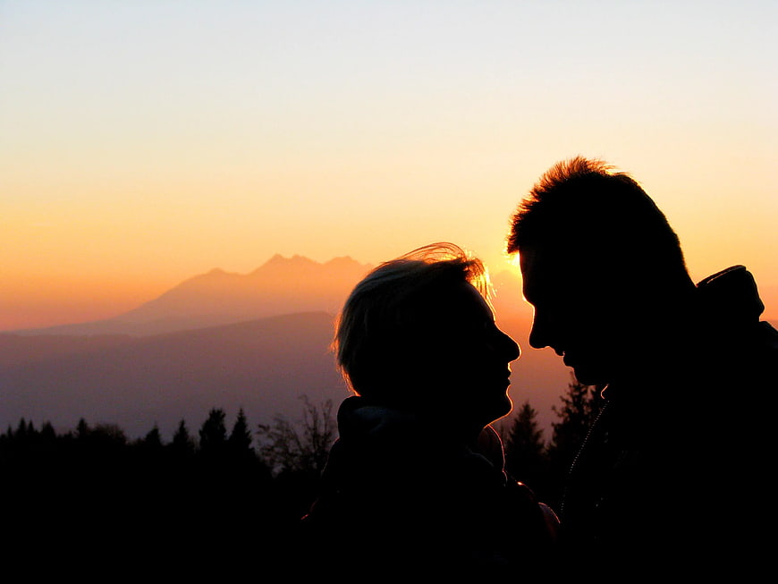 Silhouette of Couple Kissing at Sunset with Mountain View