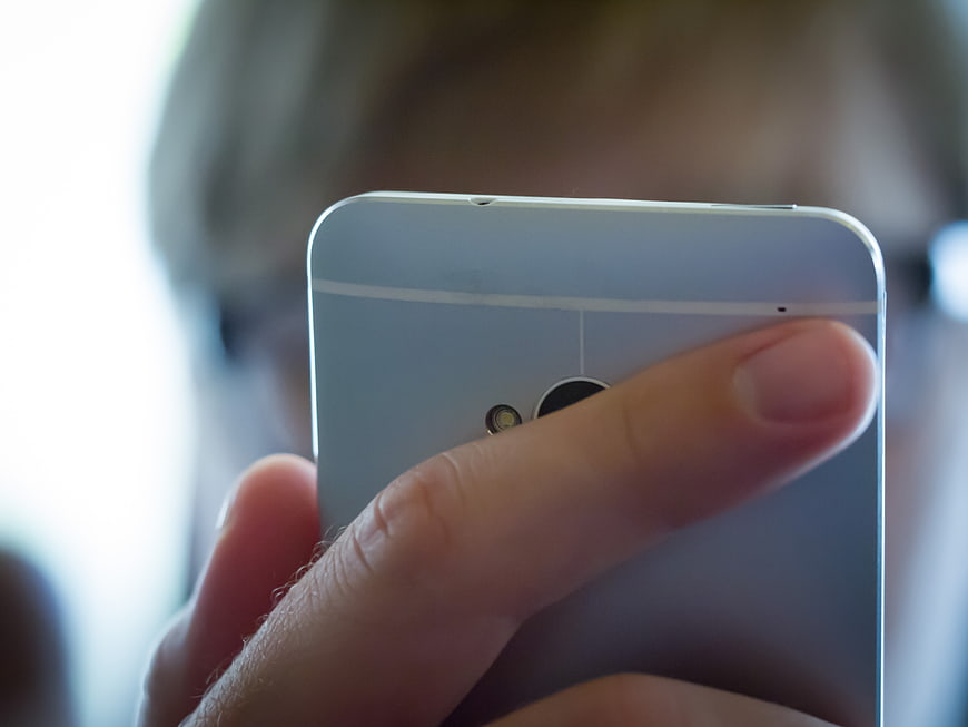 Close-up of hand holding silver smartphone