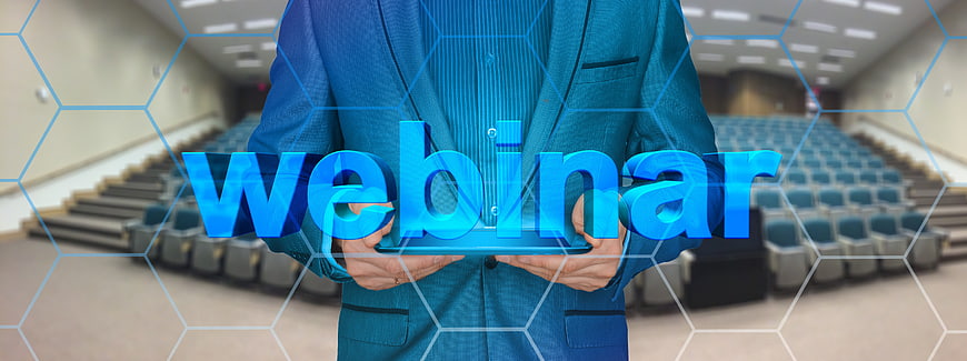 Businessman holding holographic webinar text in lecture hall