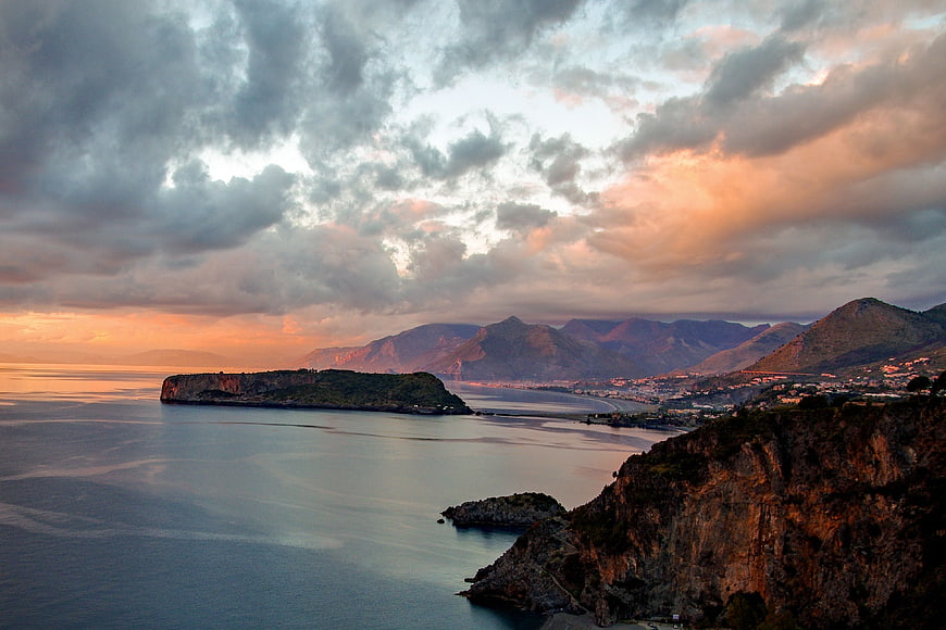 Dramatic Sunset Sky Over Coastal Landscape and Mountains