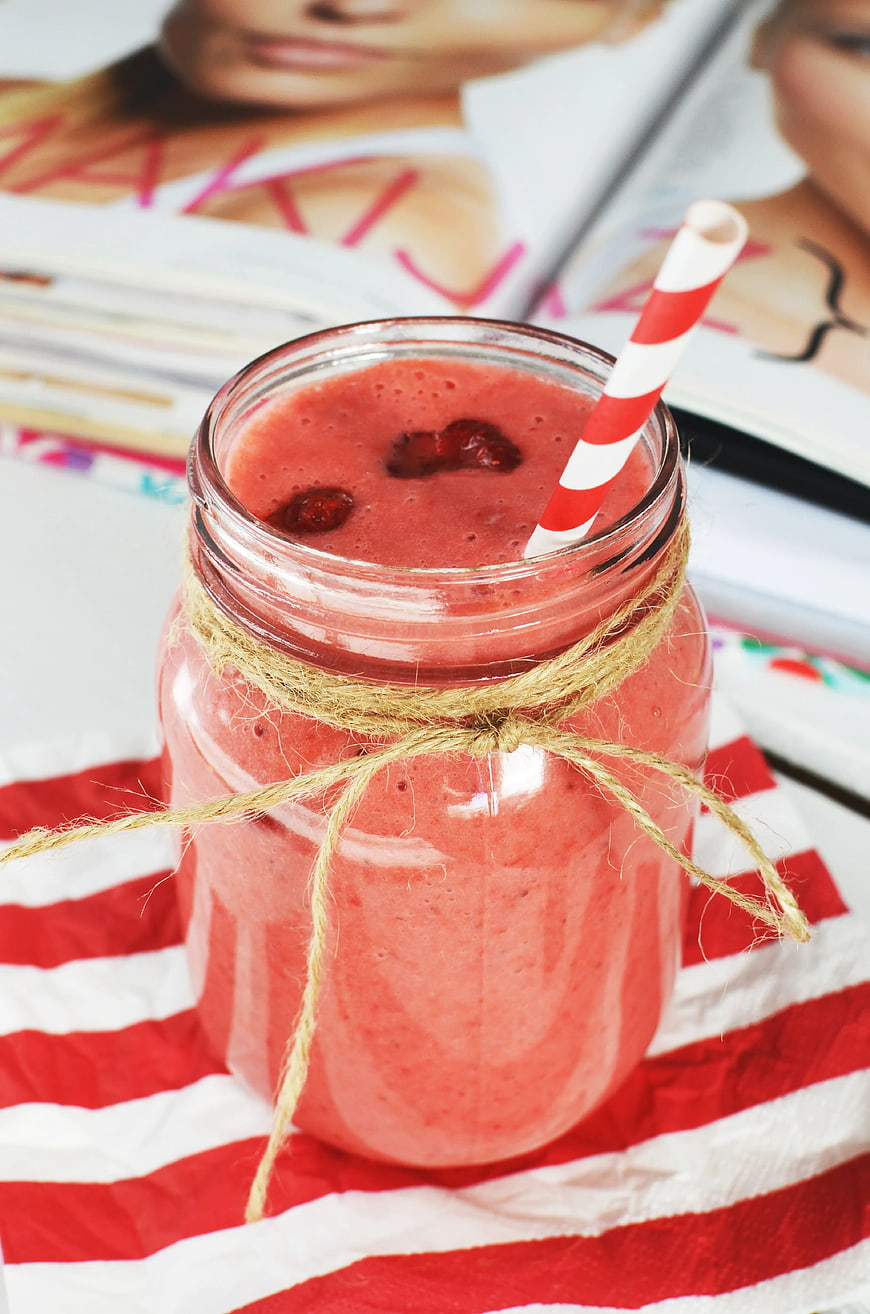 Strawberry smoothie in mason jar with striped straw