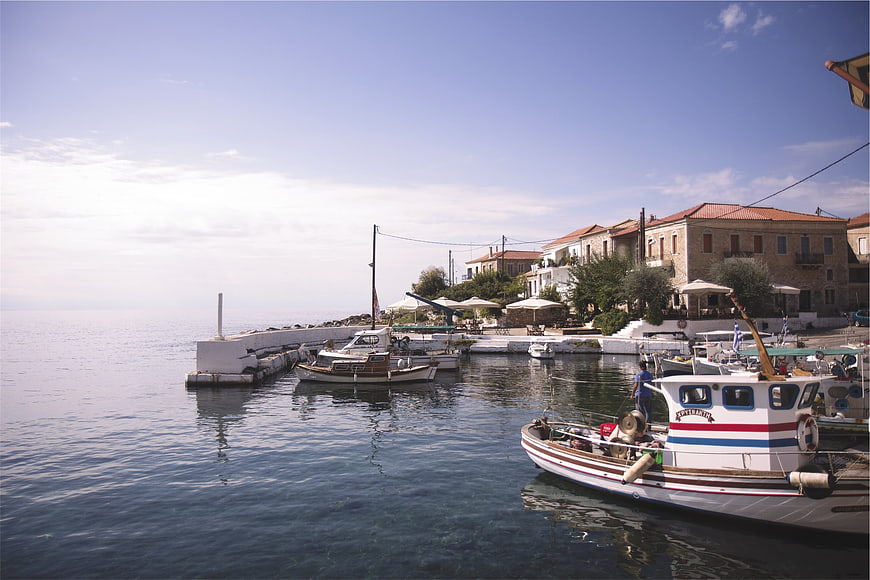 Traditional fishing boats in a sunny Greek harbor