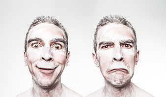 Man with white face paint showing happy and sad expressions