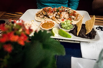 Chicken tacos with rice, beans, and guacamole on a plate