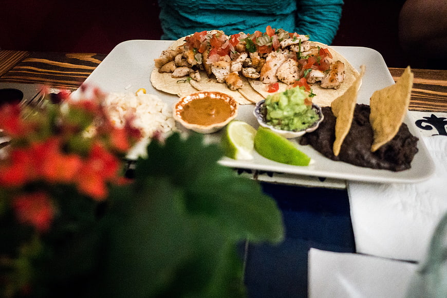 Chicken tacos with rice, beans, and guacamole on a plate