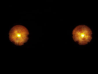 Two glowing amber warning lights on black background