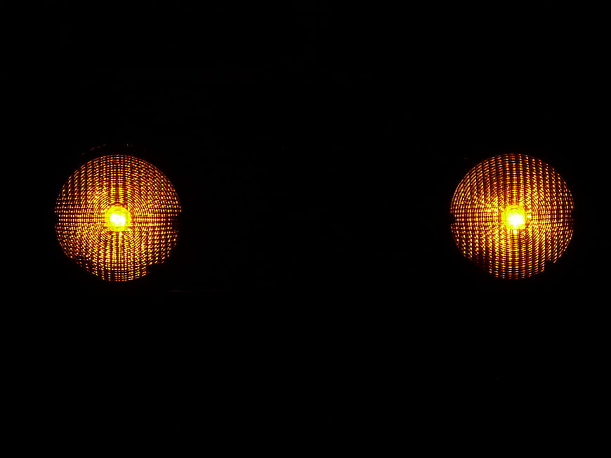 Two glowing amber warning lights on black background