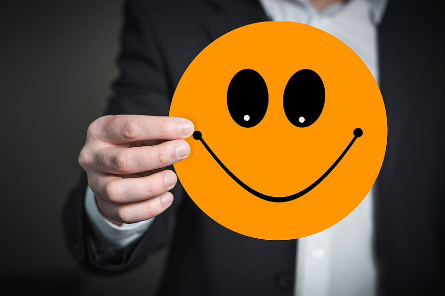 Businessman holding orange smiley face emoji card
