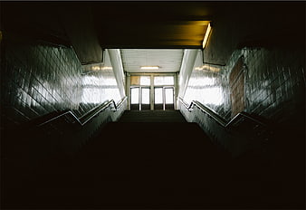 Dark Symmetrical Staircase Leading to Bright Exit Doors