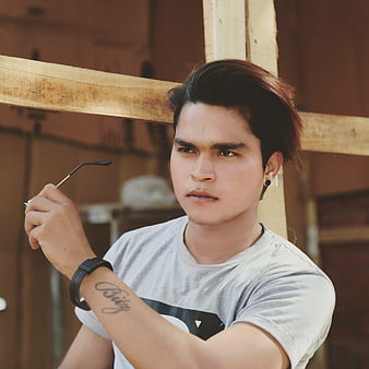 Stylish Young Man with Tattoo Holding Sunglasses