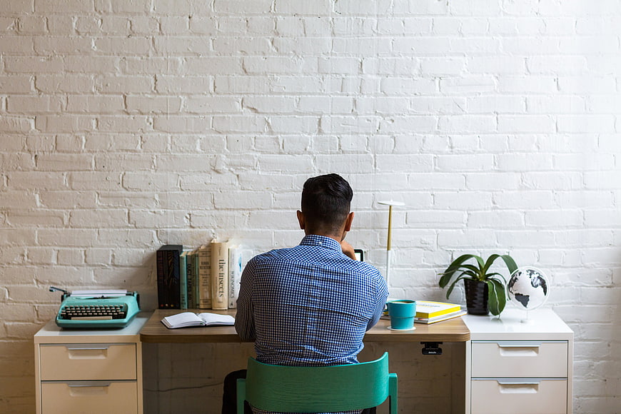 Man working at desk in modern office with typewriter