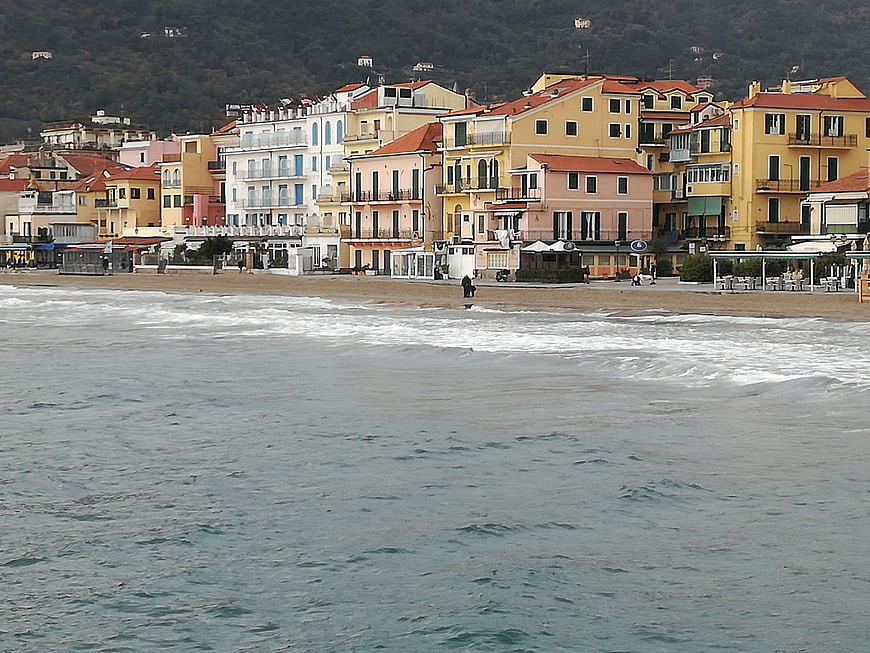 Colorful coastal town buildings along sandy beach in Liguria, Italy