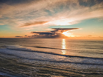 Golden Sunset Over Ocean With Dramatic Clouds and Waves