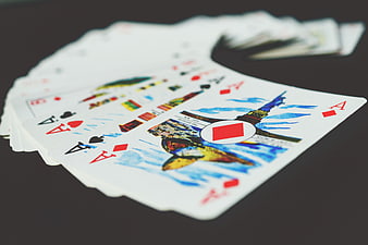 Fan of playing cards with four aces on dark background