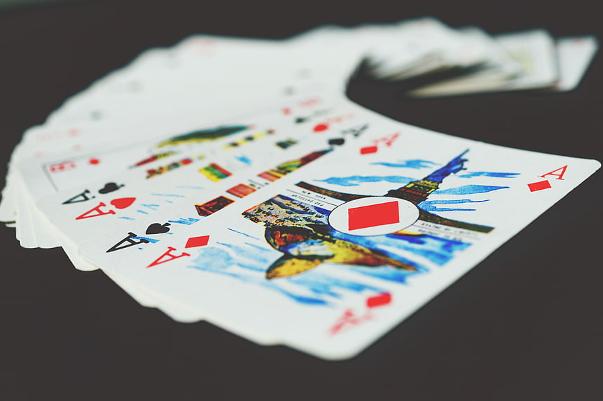 Fan of playing cards with four aces on dark background