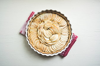 Top view of homemade apple tart on white wooden table