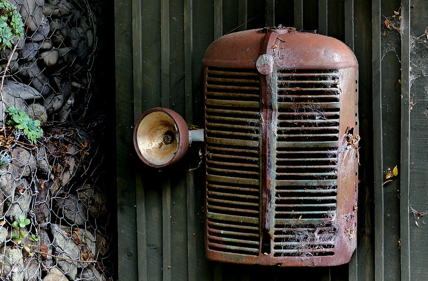 Rusty vintage truck grille mounted on wooden wall