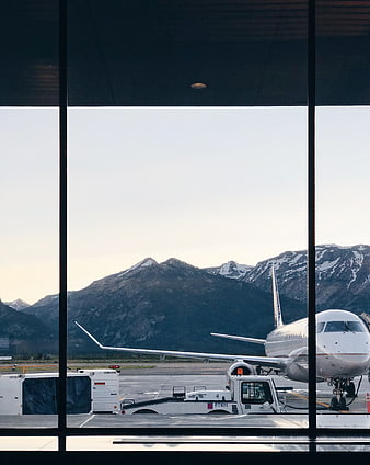 Airplane at Airport Terminal with Mountain View