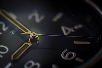 Close-up of vintage black watch face with gold hands
