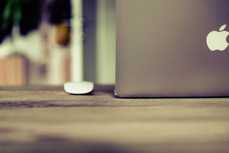 Close-up of MacBook on Wooden Desk with Mouse