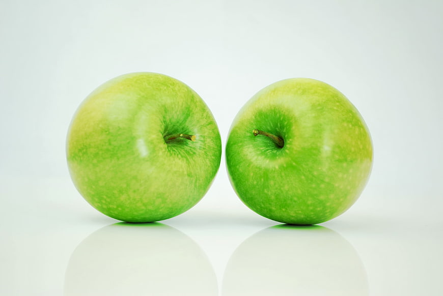 Two fresh green apples on white background