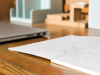 Wireframe Sketches in Notebook on Wooden Desk