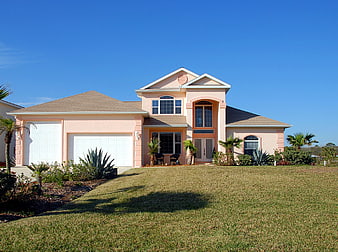 Pink Two-Story House with Blue Sky and Green Lawn