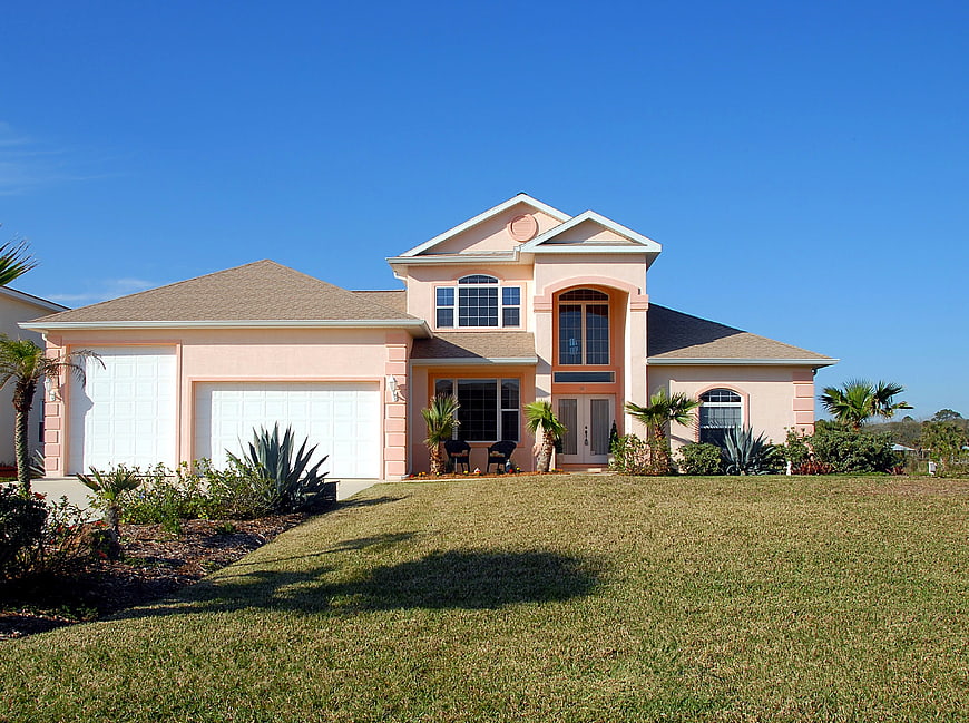 Pink Two-Story House with Blue Sky and Green Lawn