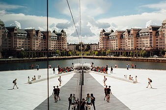 Wide angle view of Oslo Opera House roof with tourists and city skyline