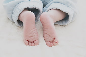 Close-up of newborn baby feet in blue pajamas