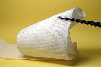 Medical Gauze Bandage Held By Tweezers On Yellow Background