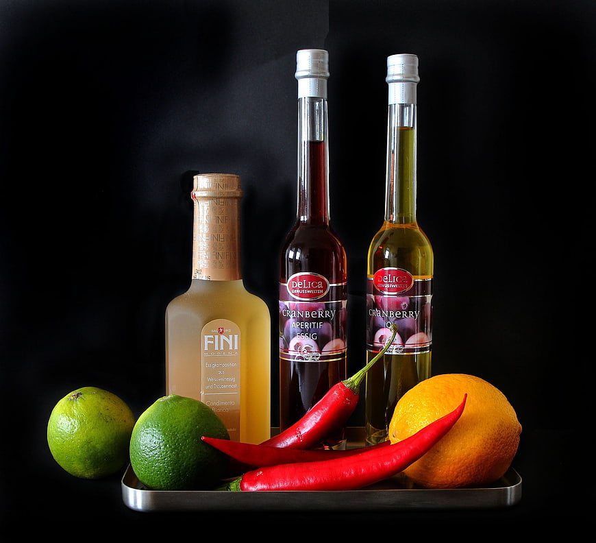 Cranberry vinegar and oil bottles with citrus and chili peppers