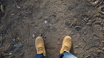 Top-down view of tan hiking boots on sandy trail