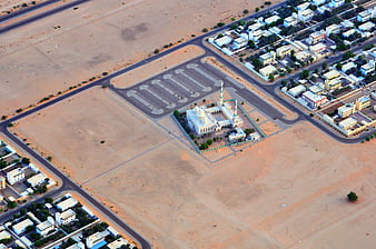Aerial view of white mosque in desert settlement