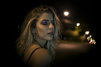 Blonde Woman with Purple Makeup at Night with Bokeh Lights